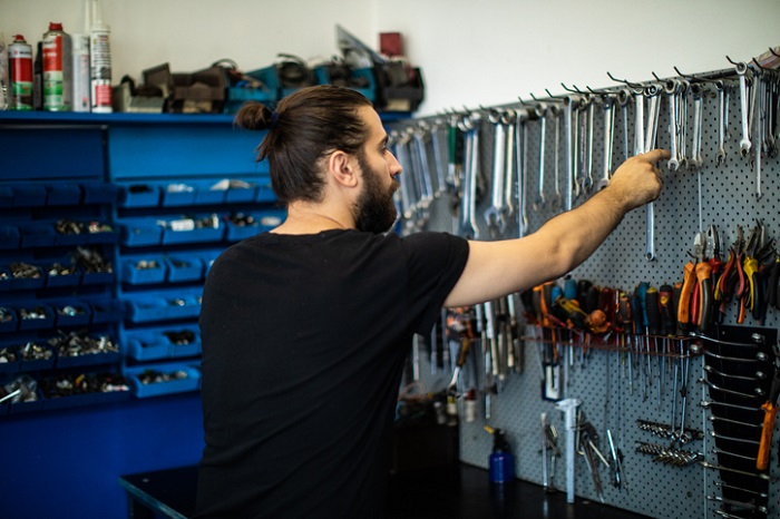 Automechaniker wählt Werkzeuge in der Werkstatt